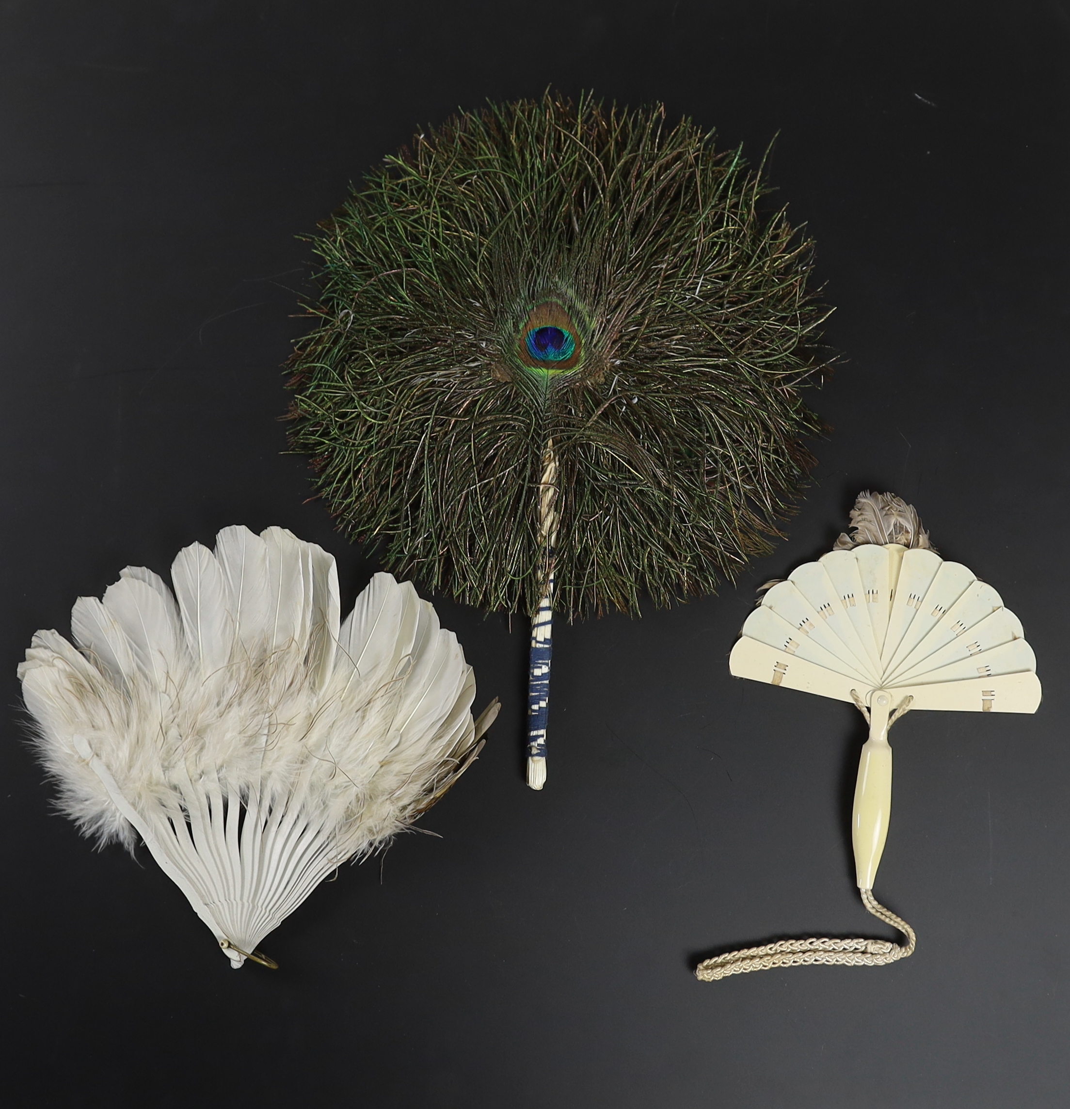 Two Edwardian early 1920’s feather fans with unusual bird decoration together with a peacock fan, one with cream Bakelite handle and guards, feather leaf and bird decoration, the other with silver painted guards, feather